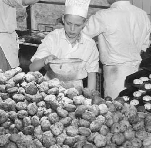 Kind voorziet oliebollen van poedersuiker